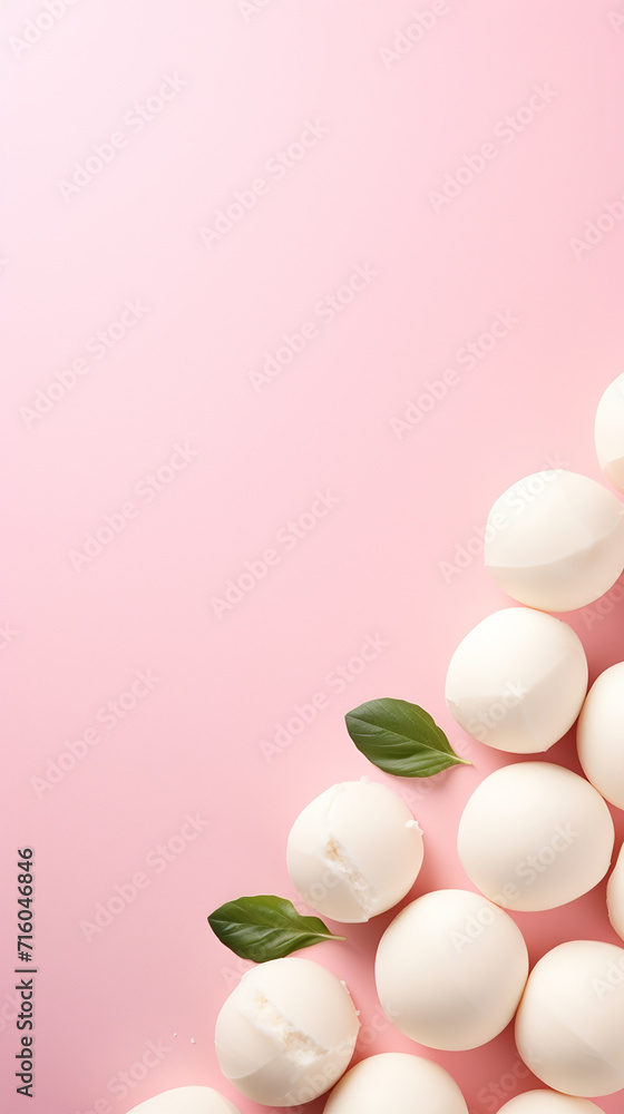 Mozzarella cheese balls on light pink background, top view, copy space	