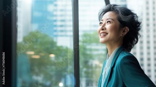 Asian middle age business woman looking at the window