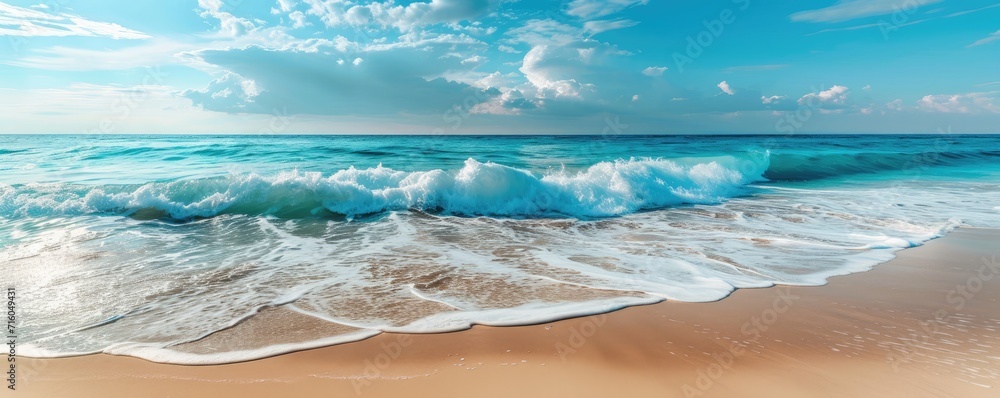 Calm beach landscape with golden sand, tranquil waves and a blue sky