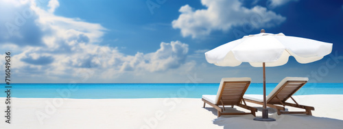 Sunbeds and umbrella on the beach, summer vacation background
