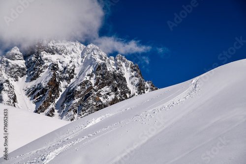 Ski tracks on the fresh snow at the off piste area at the Meribel Ski Resort in France. Beautul view to the mountains on the background. photo