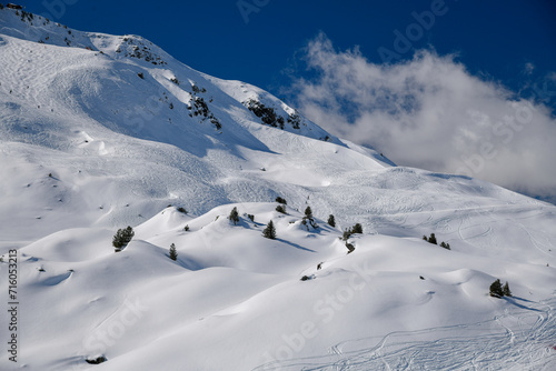 Ski tracks on the off piste terrain at the Meribel Ski Resort in France. Beautiful sunny day with blue sky.