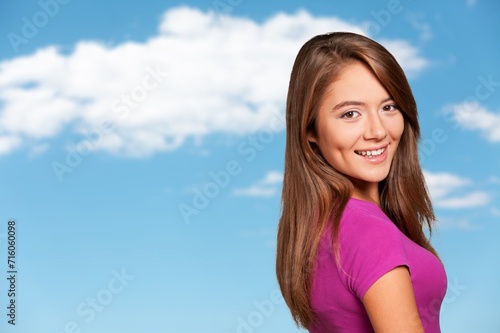smiling young smart woman standing on blue background
