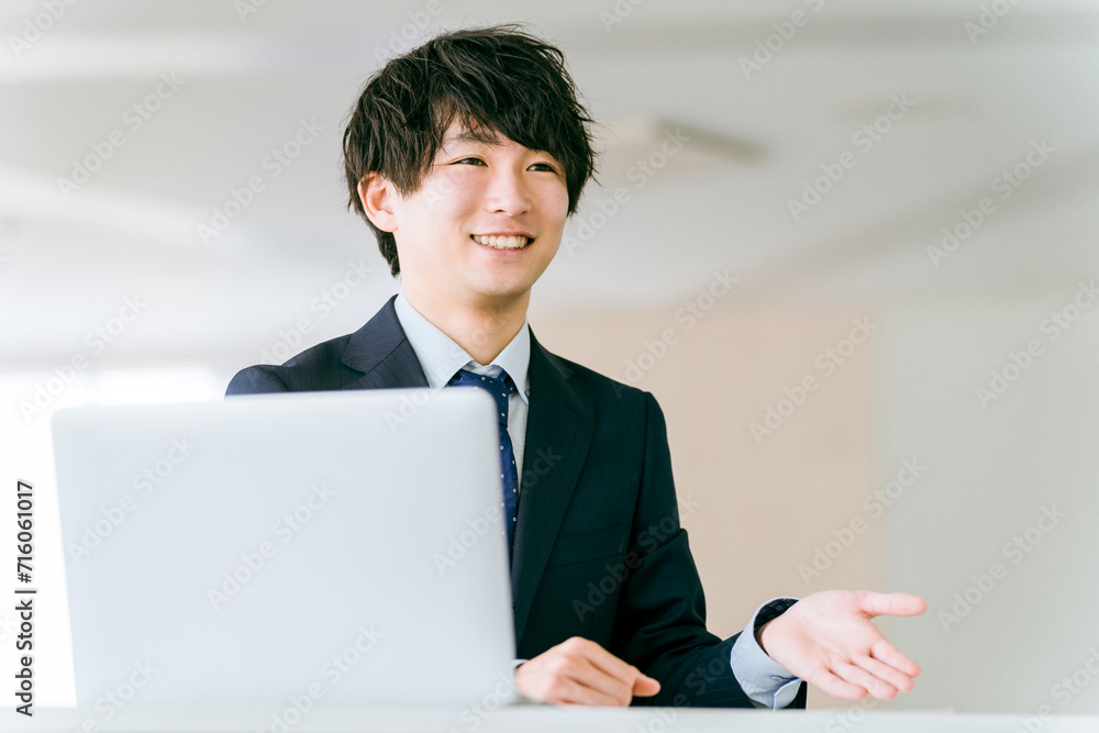 ノートパソコンを使い提案する若いビジネスマン
