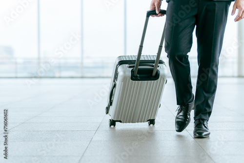 スーツケース・キャリーケースを持って出張に行くビジネスマン・海外出張・海外赴任・商社・貿易
 photo