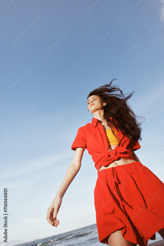 Summer Bliss: Smiling Woman Dancing in Red Clothes on a Sunny Beach