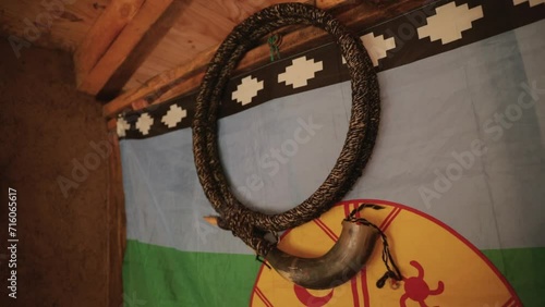 Culture and tradition. View of a Mapuche aborigine musical instrument, Ñolkin that belongs to the family of the trumpets and is made with wood and animal guts. The Mapuche flag hanging in the wall.  photo