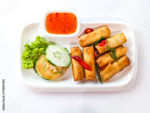 Deep fried spring rolls or “popia” in Malay, serve with hot sauce in white plate