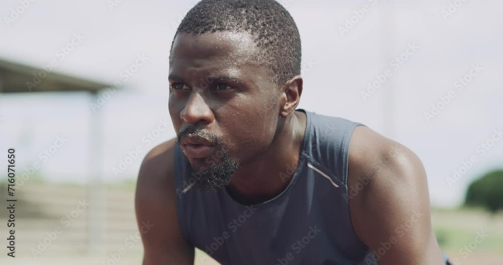Black man, start and getting ready for running, race or outdoor exercise in fitness or competition on stadium track. Active African male person or athlete in training for sprint or sports marathon Black man, start and getting ready for running, race or outdoor exercise in fitness or competition on stadium track. Active African male person or athlete in training for sprint or sports marathon