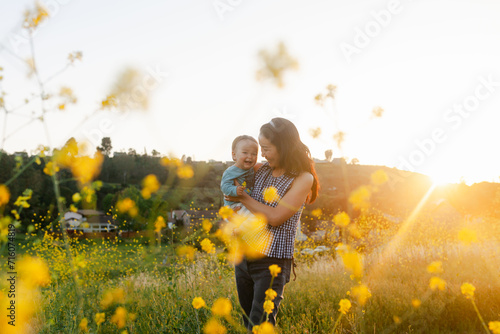 Mom and baby in the yellow mustard field playing © Kaori