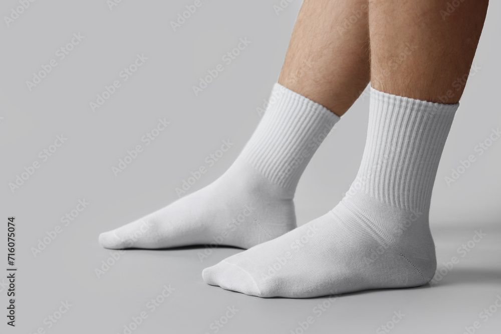 Man in stylish white socks on light grey background, closeup Man in stylish white socks on light grey background, closeup
