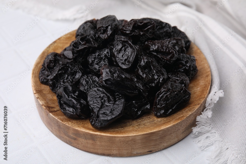 Sweet dried prunes on white tiled table, closeup Sweet dried prunes on white tiled table, closeup
