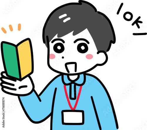 笑顔で初心者マークを持つ介護スタッフの若い男性(上半身・ポロシャツ)