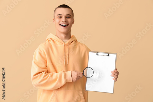 Young man with magnifier an...