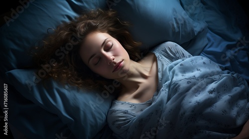 Relaxing young woman sleeping cozily on bed in bedroom at night with copy space for text