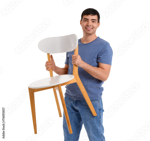 Young man carrying chair on...