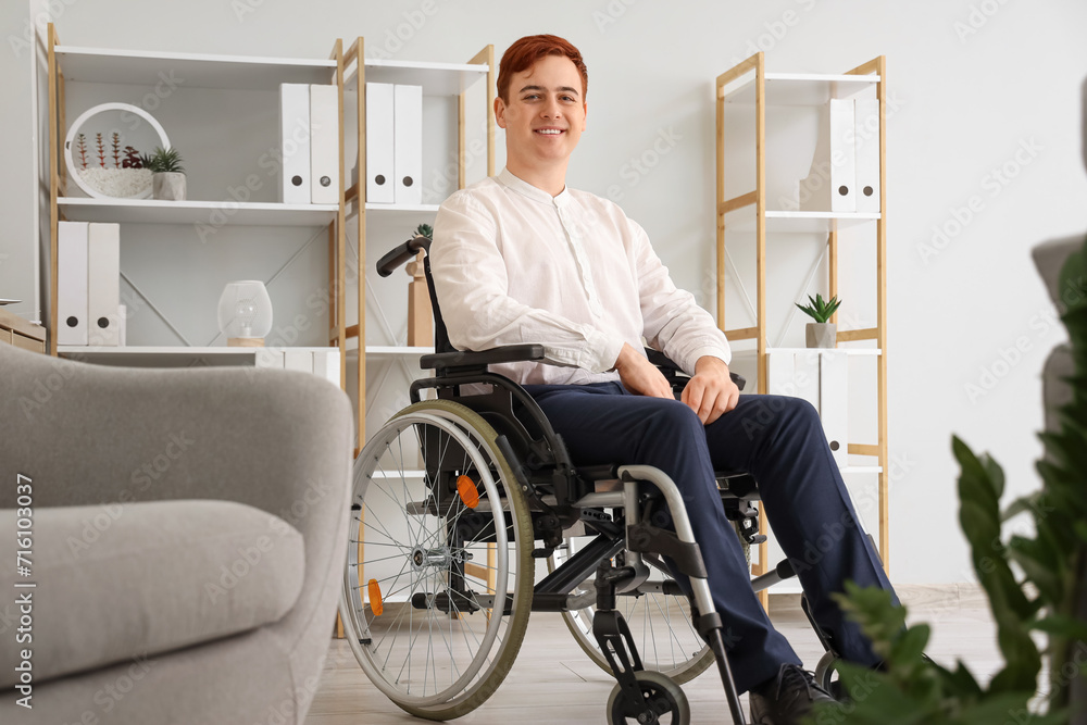 Young businessman in wheelchair at office Young businessman in wheelchair at office