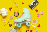 Composition with vintage roller skate, photo camera and cosmetic products on yellow background