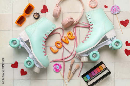 Composition with pair of vintage roller skates, modern headphones and cosmetic products on light tile background