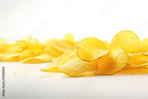 Yellow potato chips with salt on a white isolated background selectively focused