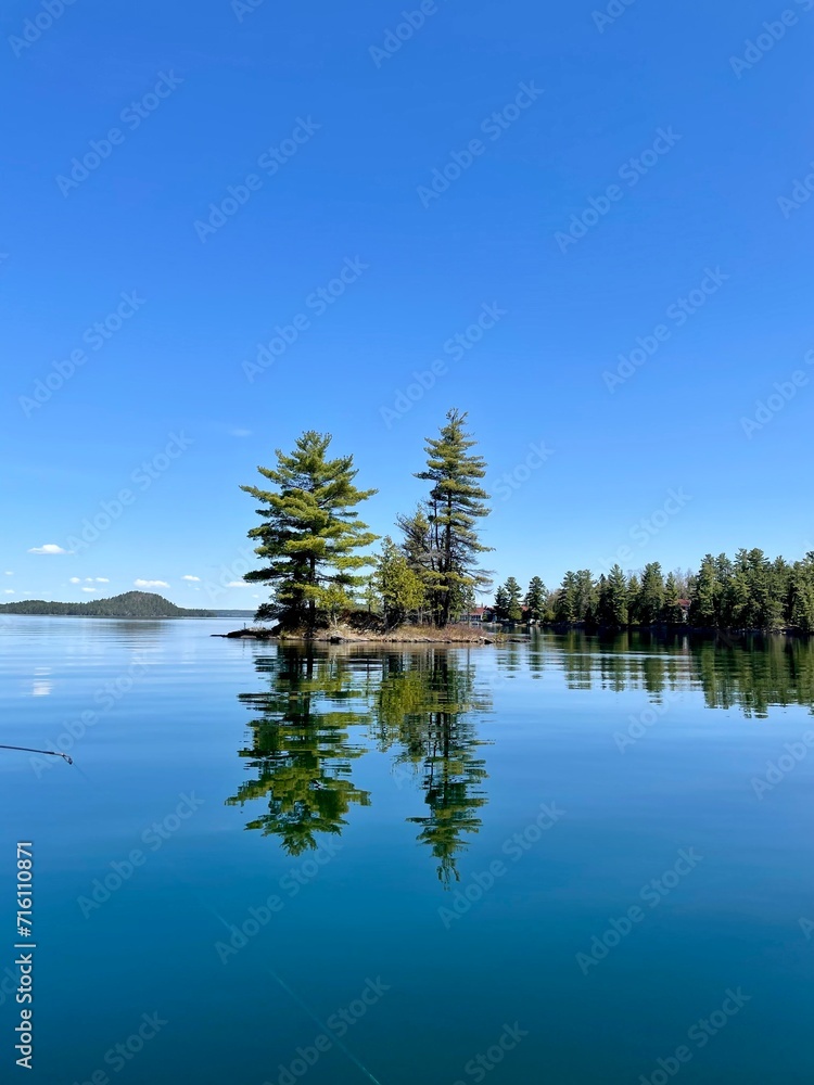 Beautiful small island, crystal clear water, in our beautiful 31 Mile Lake, Gracefield, Quebec, Canada. Photo taken while fishing on a beautiful sunny day.