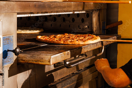 Pulling a pizza out of the oven