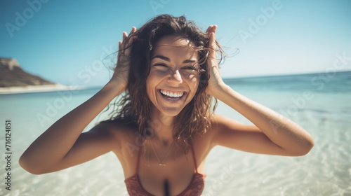 Fotografie, Obraz A Close up image of smiling woman in swimwear on the beach making a heart shape with hands - Pretty joyful hispanic woman laughing at camera outside - Healthy lifestyle