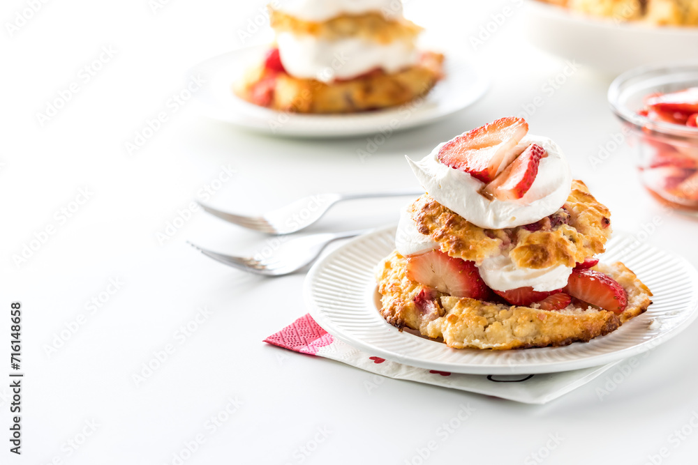 Servings of homemade mini strawberry shortcakes, against a bright background. Servings of homemade mini strawberry shortcakes, against a bright background.