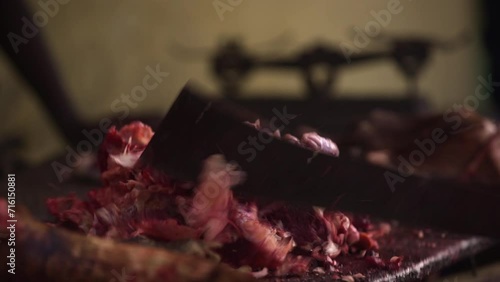 A market seller chops bones with a machete