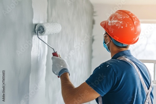 professional painter Applying a roller to paint the walls of the house. Home renovation concept