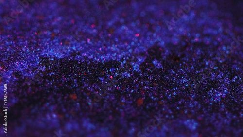 Sparkling fluid flow. Bokeh light. Defocused neon purple pink black color shimmering glitter texture gel ink wave motion abstract art background.