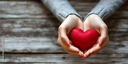 Young women hands holding red heart on wood background  health care  donate and family insurance concept