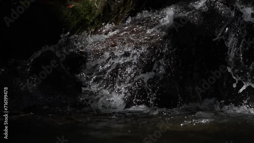 water flowing from a fountain to the river in slow motion photo