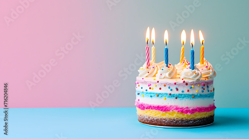 A mouth-watering birthday cake with vibrant candles, beautifully decorated with sugary icing and fondant, stands tall on a cake stand, ready to be devoured by loved ones celebrating indoors photo