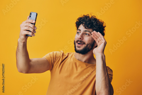 Young man happy person photogenic guy portrait smartphone adult yellow mobile technology background phone © SHOTPRIME STUDIO