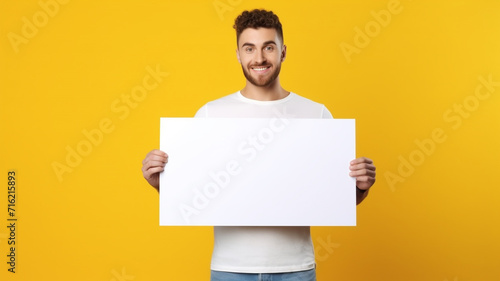 a handsome man holding a blank placard sign poster paper in his hands photo