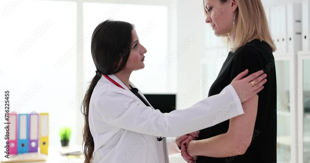 Doctor talking and supporting sad female patient in clinic Doctor talking and supporting sad female patient in clinic