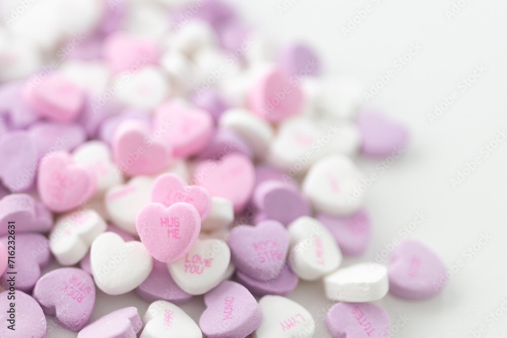 Background for Valentine's Day. Assorted pink, purple, white heart shaped candies with printed messages of love. Messages about kisses. Gift for Women's Day, March 8 Background for Valentine's Day. Assorted pink, purple, white heart shaped candies with printed messages of love. Messages about kisses. Gift for Women's Day, March 8