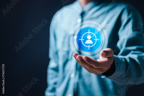 Targeting customer concept. Businessman holding virtual target customer icons for customer focus group. Digital marketing online, CRM, Data exchanges development and customer service.