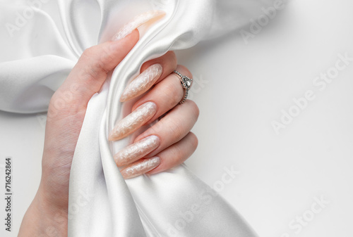 Hand of a young woman with white pearl  manicure photo