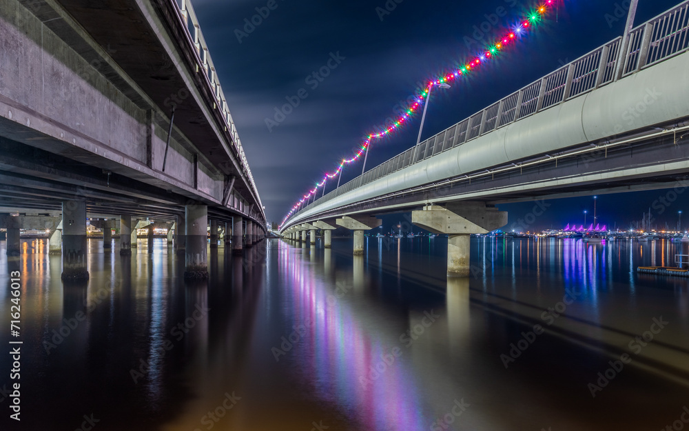 A view between the two road sections of the Sundale Bridge with lights and reflections at night on the Gold Coast in Queensland, Australia.