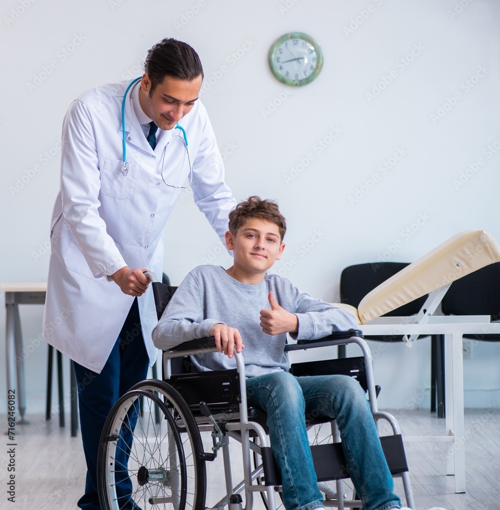 Young male doctor pediatrist and boy in wheel-chair Young male doctor pediatrist and boy in wheel-chair