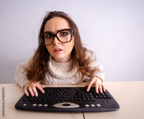 Funny nerd girl working on computer