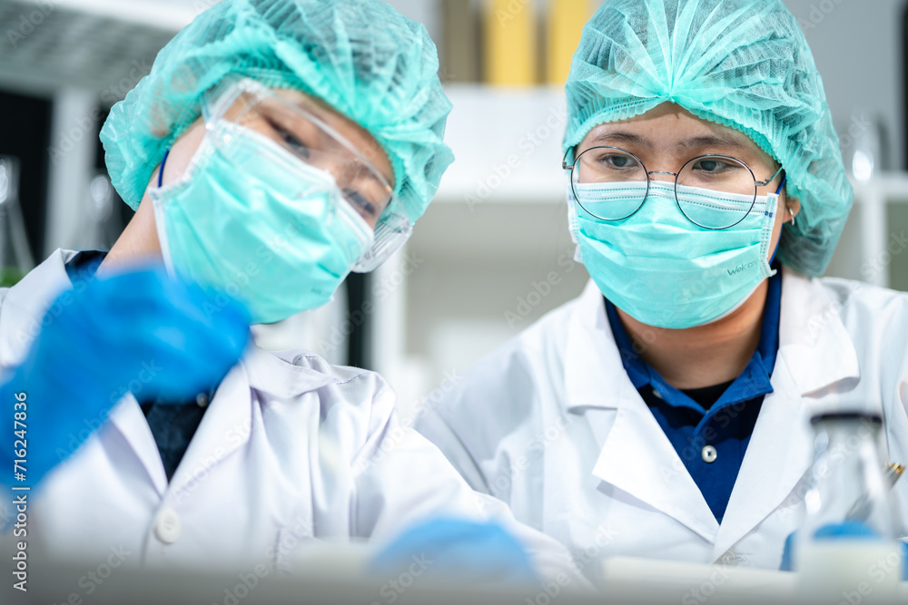 A Scientists or nutritionists are working on a sample of milk in biotechnology laboratory, genetic and bacteria research, dairy product quality control, protein, glucose and lactose percentage test. A Scientists or nutritionists are working on a sample of milk in biotechnology laboratory, genetic and bacteria research, dairy product quality control, protein, glucose and lactose percentage test.
