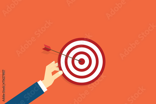 Hand holding a target, showing a goal. Red arrow hits the center. Business challenge failure and success concept.	