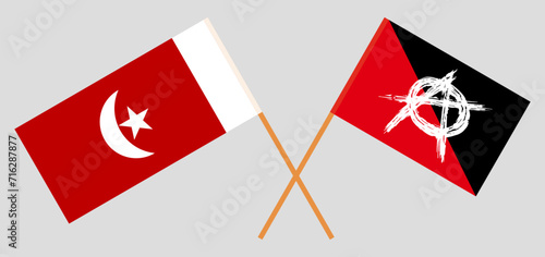 Crossed flags of The Emirate of Umm Al Quwain and anarchy. Official colors. Correct proportion photo