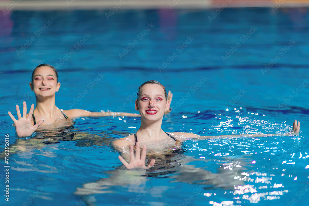 Fototapeta premium The elegance of a synchronized swimming female duet during their dedicated training session, mastering intricate moves with fluidity and precision