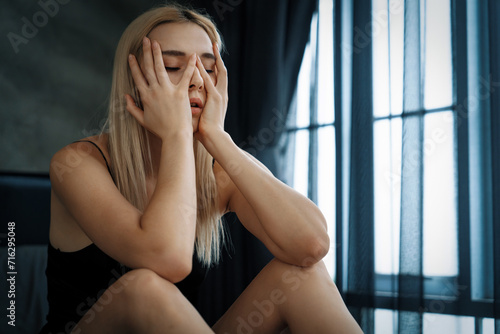 Cuadro en lienzo Young woman with critical depression and anxiety disorder from loneliness, mental sickness, or unwanted pregnancy, cuddling herself on dark bedroom