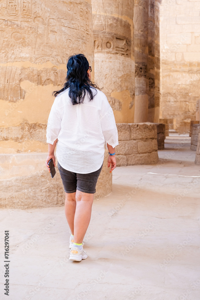 Woman traveler explores the ruins of the ancient Karnak temple in the city of Luxor in Egypt.