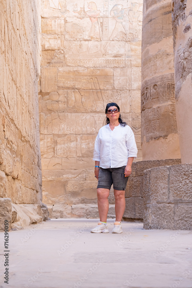 Woman traveler explores the ruins of the ancient Karnak temple in the city of Luxor in Egypt.